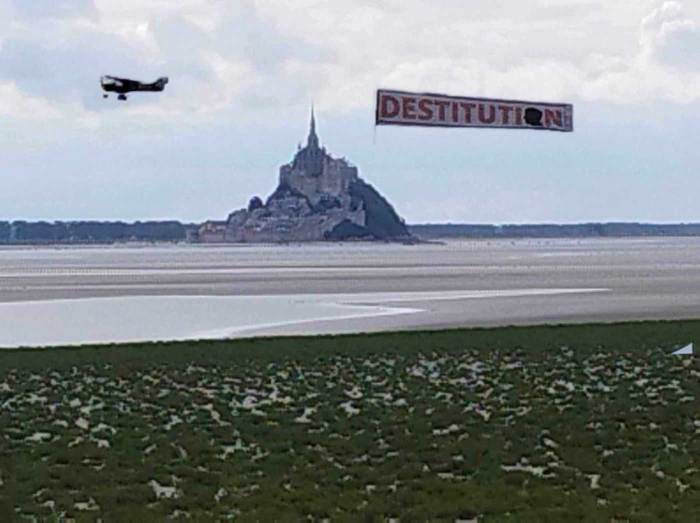 Banniere Destitution flottant au dessus du Mont Saint-Michel